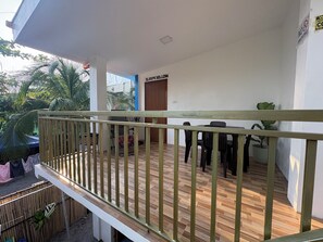 Un balcon avec une balustrade en bois, une table avec des chaises et une pancarte sur laquelle on peut lire : « SLEEPY HOLLOW ».