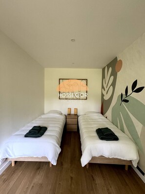 Una habitación con dos camas, una obra de arte en la pared y un diseño decorativo.