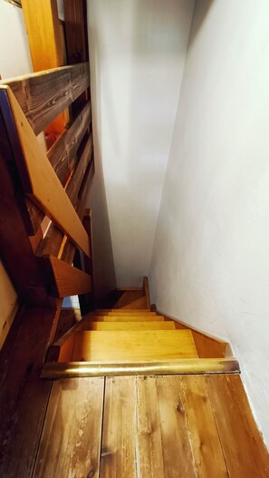 A wooden staircase with a handrail leading to a landing. - Appartamento Monti e sole (Folgarida)