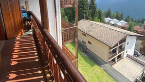 Ein hölzerner Balkon mit Blick auf einen Berg und eine Wohngegend.