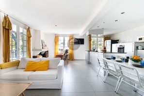 A modern living room with a sofa and a dining area with a table and chairs. - Villa Her Den - Hossegor - Town center - Lake (Soorts-Hossegor)