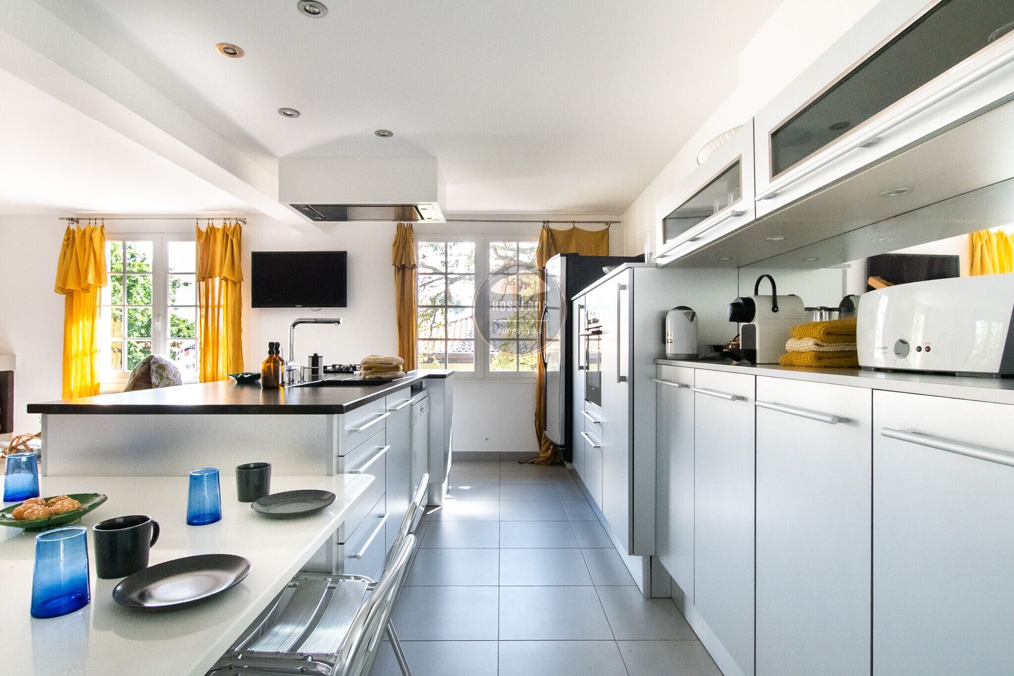 Cocina moderna con una isla central, electrodomésticos integrados y un amplio ventanal que proporciona luz natural.