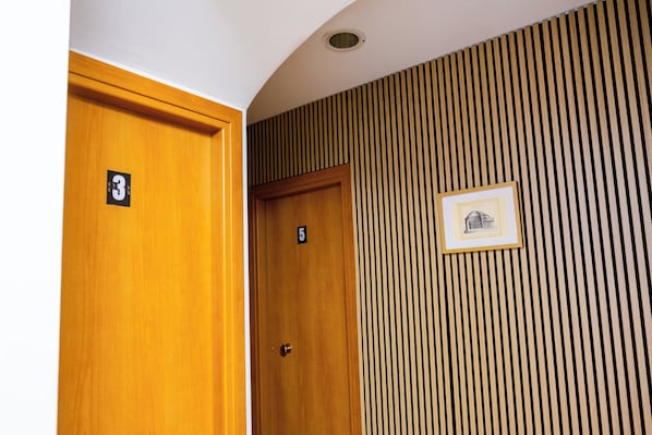 A hallway with two wooden doors, one labeled with the number 3 and the other with the number 5.