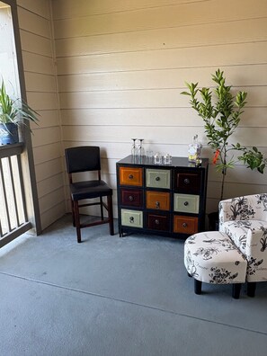 A corner room with a wooden wall, a black chair, a multi-colored cabinet, and a patterned sofa. - This place has Everything!! 2-bdrm 2 bth Apt in beautiful HTown with Pool,Gym, (Houston)