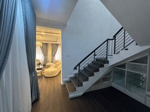 A modern interior with a staircase, a round chair, and a dining area. - Luxury 4-Bedroom Duplex in Lekki with Snooker, Jacuzzi, Fast Wi-Fi & 24/7 Power (Lekki)