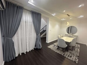 A modern interior with a dining area, a staircase, and a mirror. - Luxury 4-Bedroom Duplex in Lekki with Snooker, Jacuzzi, Fast Wi-Fi & 24/7 Power (Lekki)