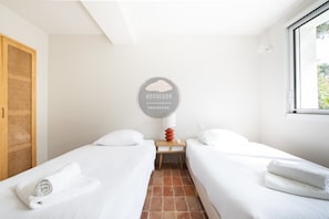 A hotel room with two beds, a small wooden nightstand, a wall-mounted sign, and a window. - Villa Analoma - Seignosse - Pool - Beach (Seignosse)