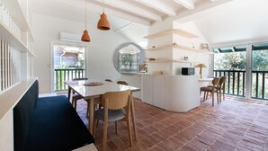 Um interior moderno com área de jantar, uma ilha de cozinha e uma janela grande.