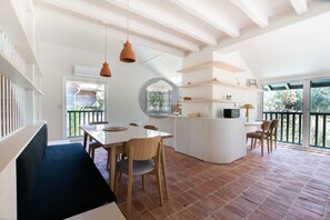 Ein modernes Interieur mit Essbereich, Kücheninsel und großem Fenster.