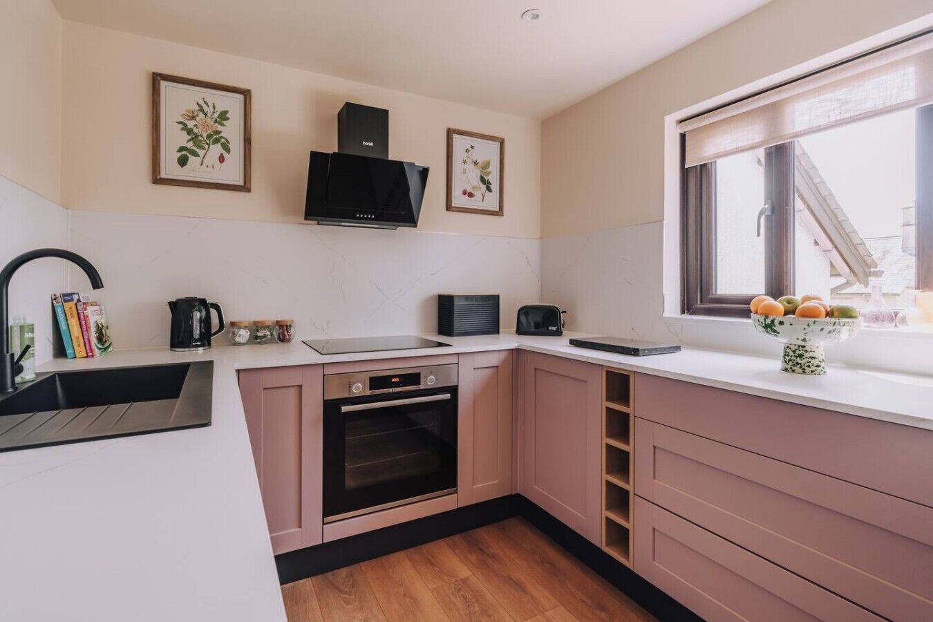 A modern kitchen with a built-in oven, a coffee maker, and a window with a view.