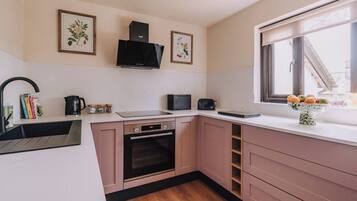 A modern kitchen with a built-in oven, a coffee maker, and a window with a view.