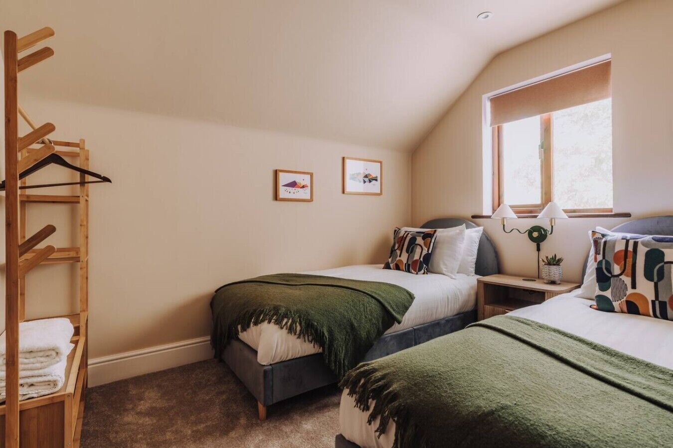 A bedroom with two beds, a wooden ladder, and a window.