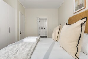 Une chambre d’hôtel avec un lit, une porte et un espace douche.
