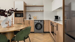 Eine moderne Küche mit integriertem Waschmaschine, einer Mikrowelle und einer Kaffeemaschine.