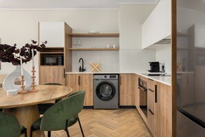 Eine moderne Küche mit integriertem Waschmaschine, einer Mikrowelle und einer Kaffeemaschine.