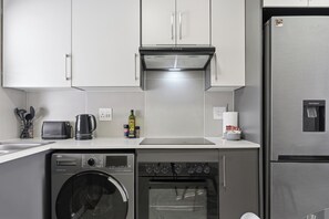 A modern kitchen with a built-in dishwasher, oven, and a water dispenser.