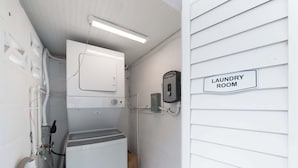 A compact laundry room with a washing machine, dryer, and a wall-mounted utility box. - 3 Min Walk to Beach | Private Triplex Retreat (Indian Rocks Beach)