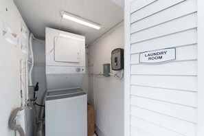Ein kleiner Hauswirtschaftsraum mit Waschmaschine, Trockner und einem fest montierten Verteilkasten.