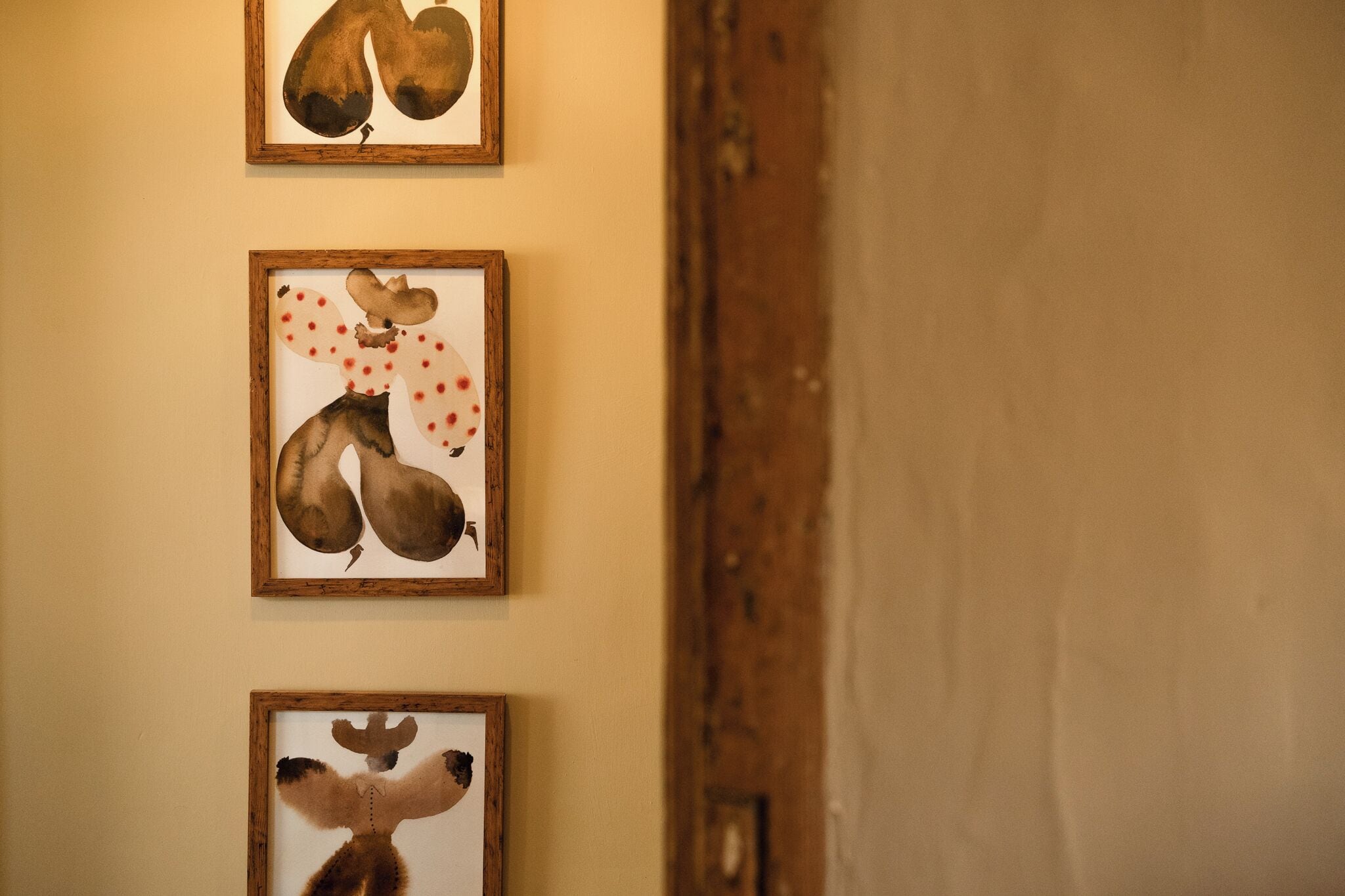 Tres obras de arte enmarcadas en una pared.
