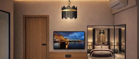 Una habitación de hotel moderna con una televisión grande, una araña, una cama y una mesita de noche.