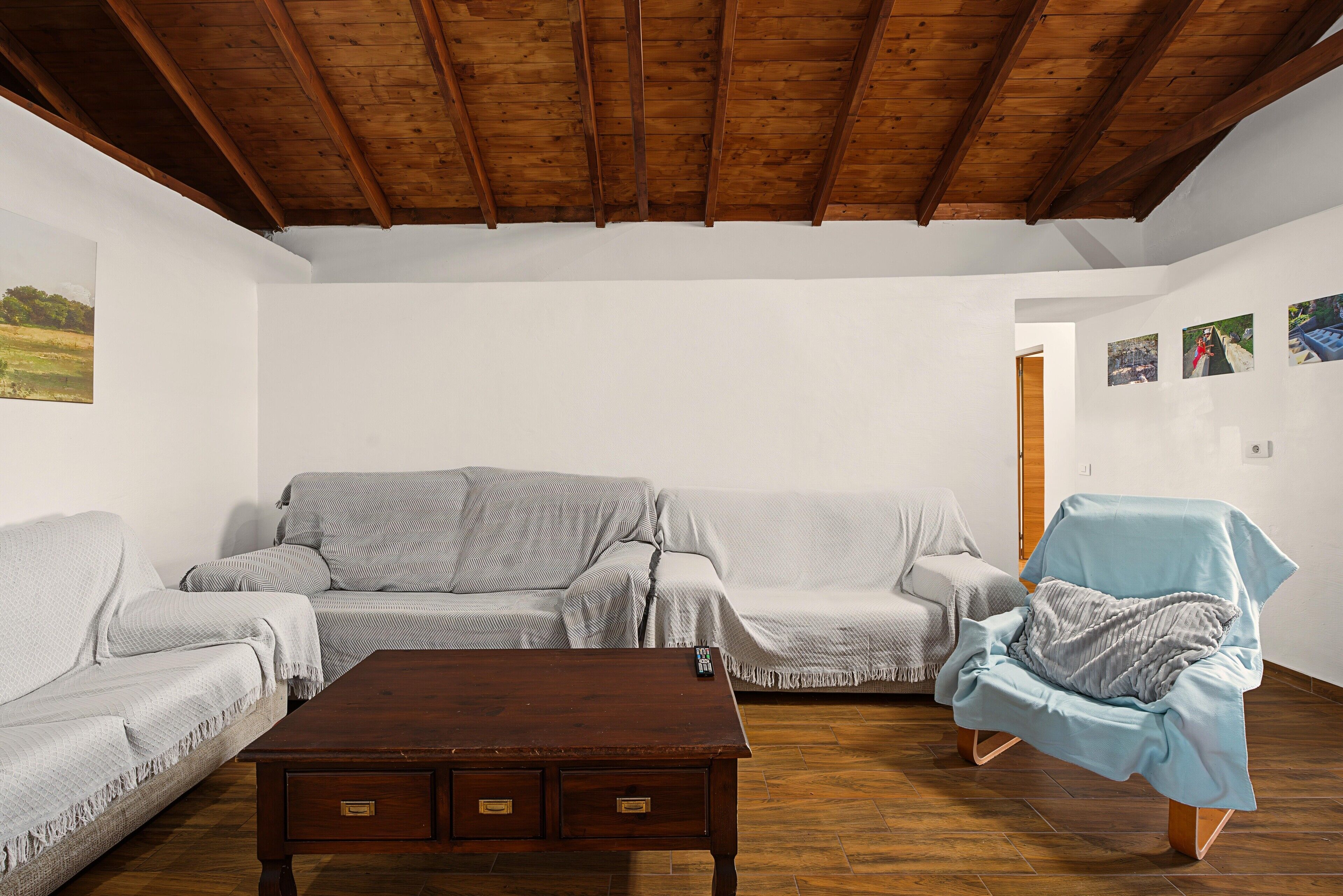 Ein Wohnzimmer mit Holzboden, einer Couch, einem Sessel und einem Couchtisch.