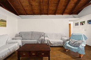 A living room with a wooden ceiling, a sofa, a chair, and a coffee table. - Holiday Home 'Los Brezos' with Mountain Views, Private Terrace and Wi-Fi (Agulo)