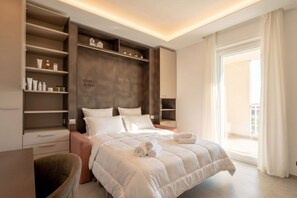 Ein modernes Schlafzimmer mit einem großen Bett, integrierten Regalen und Blick ins Freie.