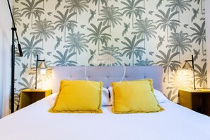 Ein Bett mit zwei Kissen, einem Kopfteil und zwei Nachttischlampen.