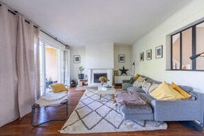 A living room with a sofa, armchairs, a coffee table, and a fireplace. - La Maison Rabier - Gare La Barre Ormesson à 300 m (Deuil-la-Barre)