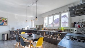 Eine moderne Küche mit Essbereich, großen Fenstern und Blick auf die Nachbarschaft.