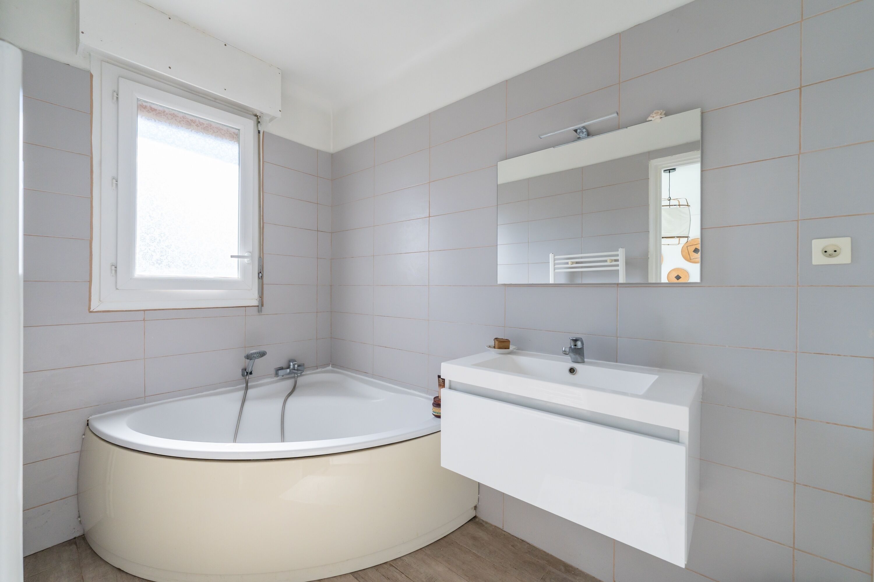 Un baño con bañera, lavamanos y espejo.