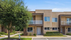 A multi-story residential building with a parking lot in front. - Stylish 4 Ensuite Home Near Disney, Free BBQ Grill (Kissimmee)
