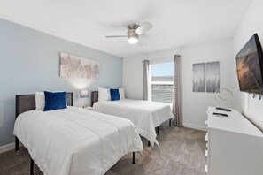 A hotel room with two beds, a ceiling fan, a TV, and artwork on the walls. - Family Friendly Home, Private Pool, Near Disney (Kissimmee)