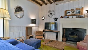 Una sala de estar acogedora con chimenea, televisor y un espejo grande en la pared.