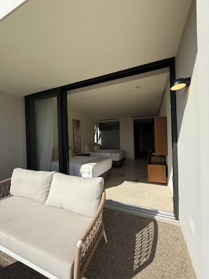 Ein modernes Hotelzimmer mit einer Couch, einem Bett und einem Badezimmer.