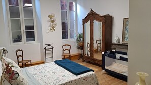A bedroom with a bed, a dresser, a mirror, and a window. - The 3-Star "Gîte de la Halle" (Beaumont-de-Lomagne)