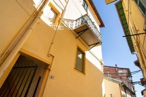A narrow street with a building corner, a visible window, and a door with a number '78' sign. - GuestHost - Azurea Home: Lovely & Spacious Apartment for 6 (Sanremo)