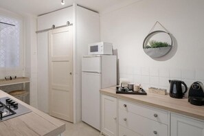 A compact kitchen with a microwave, kettle, and a small plant decoration. - GuestHost - Azurea Home: Lovely & Spacious Apartment for 6 (Sanremo)