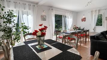 A dining area with a table set for four, surrounded by chairs, and a black and white checkered floor mat.