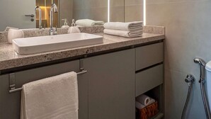 A modern bathroom with a large mirror, two sinks, a towel rack, and a shower area. - Beachfront w/ an amazing rooftop - Prime location (Salvador)