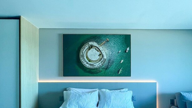 A modern bedroom with a large bed, a nightstand, a bedside table, and a wall-mounted artwork. - Beachfront w/ an amazing rooftop - Prime location (Salvador)
