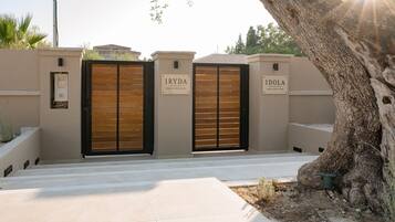 Een toegangshek met twee borden waarop 'IRYDA' en 'IDOLA' staan voor Black & White Villas.