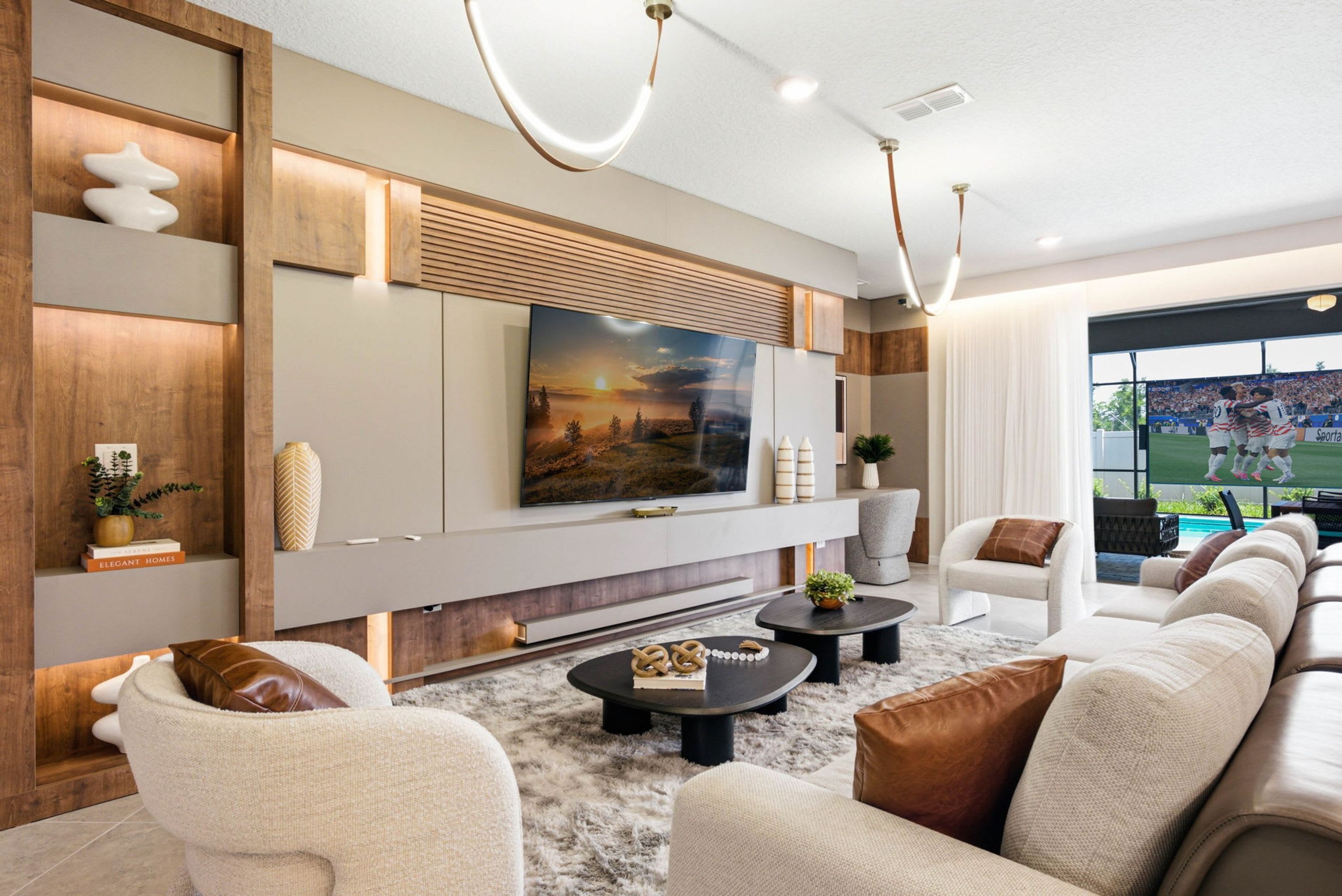 A modern living room with a large flat-screen TV, comfortable seating, and a view of an outdoor sports event.