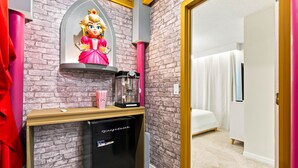 A room with a brick wall, a bed with white curtains, a small desk with a coffee machine, and a refrigerator. - Orlando Most Incredible Themed 10br Villa (Clermont)