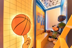 Ein basketballbezogenes Zimmer mit Spinden, einer Maskotte und einem Basketballkorb.