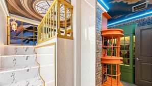 A staircase with marble steps and a golden railing, a spiral orange bookshelf, and a ceiling with a starry design. - Orlando Most Incredible Themed 10br Villa (Clermont)