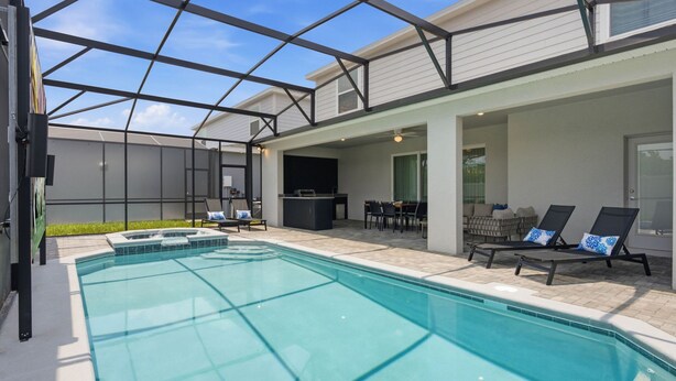 A swimming pool with a glass enclosure, a barbecue area, and outdoor seating. - Orlando Most Incredible Themed 10br Villa (Clermont)