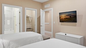 A hotel room with two beds, a TV mounted on the wall, and a small white cabinet. - Stylish 4 Ensuite Home Near Disney Free BBQ Grill (Kissimmee)