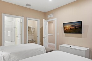 A hotel room with two beds, a TV mounted on the wall, and a small white cabinet. - Stylish 4 Ensuite Home Near Disney Free BBQ Grill (Kissimmee)