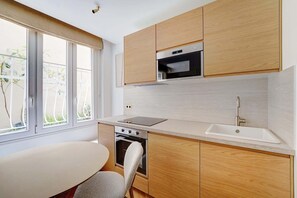 Eine moderne Küche mit Holzausstattung, Backofen, Mikrowelle und einem großen Fenster.